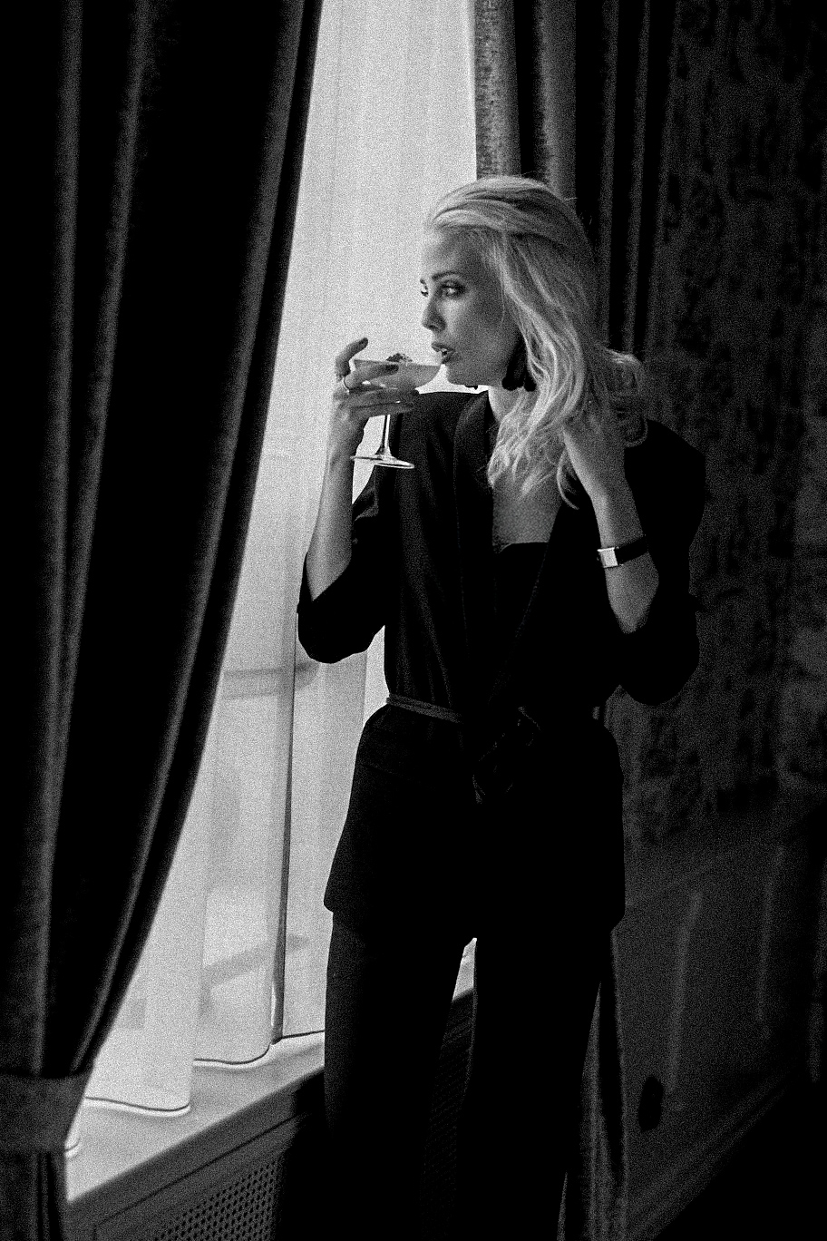 pigalle-suitebelle-drinks Kvinna står i fönstret och dricker en drink